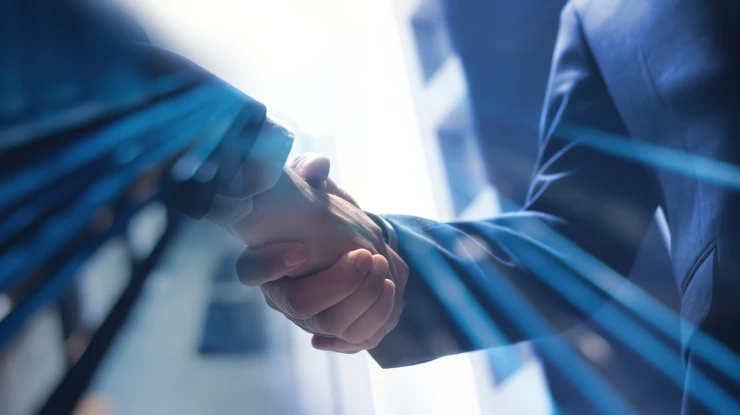 Poignée de main entre deux professionnels en costume, symbolisant un partenariat stratégique autour d’une solution ERP rentable et sur mesure.